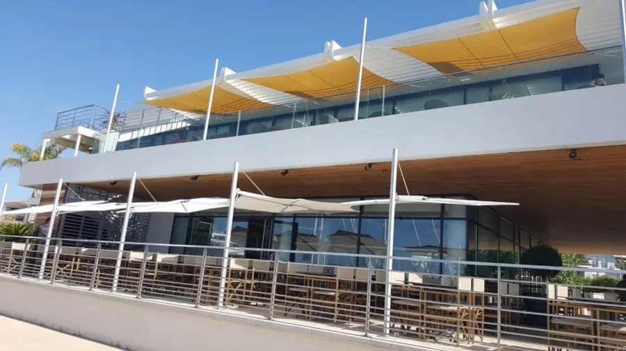 Žluté plachty Ingenua a slunečníky Spectra nad terasou restaurace